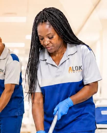 Auxiliar de limpeza da Alok Service higienizando o corredor de um hospital